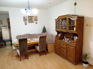 a dining room with a table and a cat sitting on a cabinet at Apartman Zivic in Berilovac