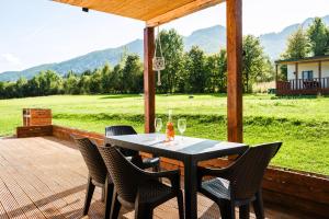 a table and chairs on a deck with a view of a field at Beaumont Lodges in Predeluţ