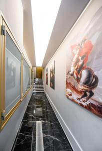 a hallway with paintings on the walls at Royal Gold City Suites in Heraklio Town