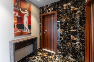 a bathroom with a stone wall and a door at Royal Gold City Suites in Heraklio