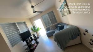 un salon avec un canapé bleu et une télévision dans l'établissement Family & Friends - Beach, BBQ, Private Pool & Pet, à Vega Baja