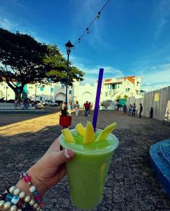 uma pessoa segurando uma bebida verde com uma palha azul em El santorini colombiano cabaña em Puerto Triunfo