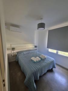1 dormitorio con 1 cama con 2 toallas en Cabañas El Rincon en Tandil