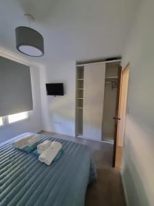 1 dormitorio con 1 cama con 2 toallas en Cabañas El Rincon en Tandil