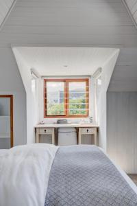 a white bedroom with a bed and a window at Beautiful Abalone in Hermanus