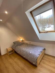 1 dormitorio con cama y ventana en Beskidzka Apartments, en Sucha Beskidzka