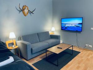salon z niebieską kanapą i stołem w obiekcie Hotel-standard design apartment with private sauna w mieście Espoo