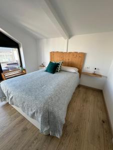 ein Schlafzimmer mit einem großen Bett und einem Fenster in der Unterkunft Duplex Casa da barbeira in Cangas