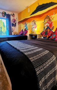 1 dormitorio con 1 cama grande y una pintura en la pared en MESON AMELIA en San Miguel de Allende
