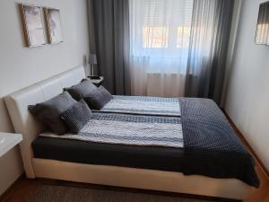 烏日策的住宿－Apartment Tufna，一间卧室设有一张大床和窗户