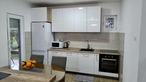 eine Küche mit weißen Schränken und einem Tisch mit Orangen darauf in der Unterkunft Entire house floor - 2-Bedroom Cozy & Peaceful Apartment in Podgorica