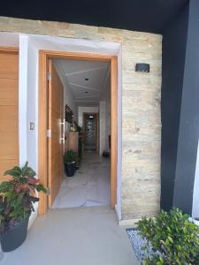 Chez Maria في القنيطرة: باب مفتوح إلى الردهة مع نباتات الفخار