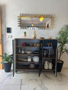una mensola con piatti sopra in una stanza con piante di Chez Maria a Kenitra
