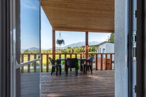 a dining table and chairs on a deck with a view at RAI Lodges Bran - Predelut in Bran +100 photos