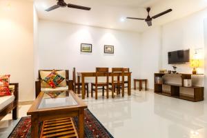 a living room with a couch and a dining room at Borail Homes in Silchar