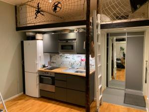 a kitchen with a loft bed with a sink and a refrigerator at Fullt utrustat Minihus på landet in Västerhaninge