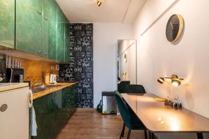 a kitchen with a wooden table and green cabinets at Double-tree apartment by A&M in Bratislava