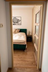 a bedroom with a bed and a door open at Double-tree apartment by A&M in Bratislava