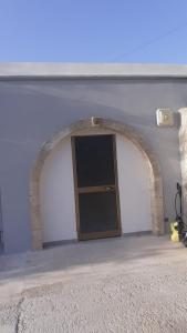 an archway in a white wall with a door at Casa il capricorno in Syracuse