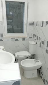 a bathroom with a toilet and a sink and a window at Casa il capricorno in Siracusa