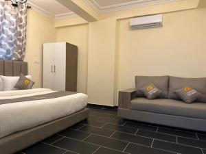 a hotel room with a bed and a couch at Cereno Homes Accra in Accra