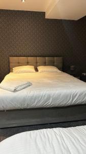 een groot bed in een slaapkamer met een witte sprei bij The Pleasant House in Manchester