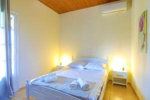 a bedroom with a bed with white sheets and pillows at Villa Serenita in Agios Georgios +24 photos