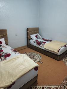 2 Betten nebeneinander in einem Zimmer in der Unterkunft Maison sahara in Ad-Dakhla