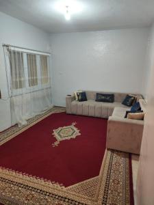 a living room with a couch and a red rug at Maison sahara in Dakhla