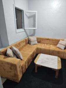 a living room with a brown couch and a table at Maison sahara in Dakhla