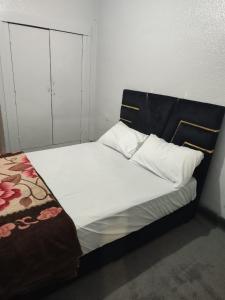 Bett mit schwarzem Kopfteil in einem Zimmer in der Unterkunft Maison sahara in Ad-Dakhla