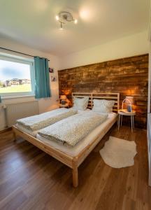 een slaapkamer met een groot bed en een bakstenen muur bij Haus Faninger - SUMMERCARD included in Kaprun