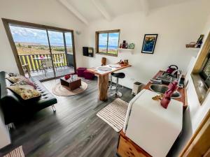 a living room with a refrigerator and a table at Maunga Roa Eco Lodge in Hanga Roa