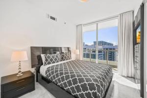 um quarto com uma cama e uma grande janela em 41st Floor Icon Brickell Corner 2 bed/2bath with Bay and CityView • 5 star SPA em Miami