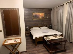 a bedroom with a bed and a table in it at Privat FoRest in Liptovský Mikuláš