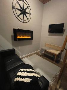 ein Wohnzimmer mit einem schwarzen Sofa und einem Kamin in der Unterkunft Tiny Home Bliss in Harcourt