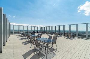 a row of tables and chairs on a balcony at Hanza Tower Sky SAUNA & JACUZZI & POOL in Szczecin