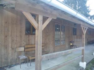 a wooden building with a bench and chairs in it at wagons dortoir in Chaudenay