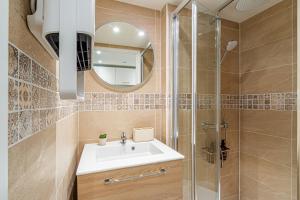 uma casa de banho com um lavatório e um chuveiro em Éden Spa & Cinéma em Les Essarts-le-Roi