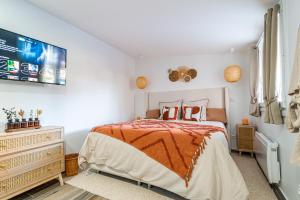 une chambre blanche avec un lit et une télévision dans l'établissement Éden Spa & Cinéma, à Les Essarts-le-Roi