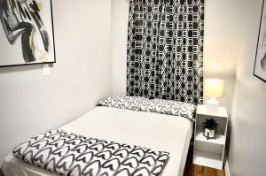 Cette chambre comprend un lit avec une chaise noire et blanche. dans l'établissement Lovely 5Bedroom apartment in NYC!, à New York
