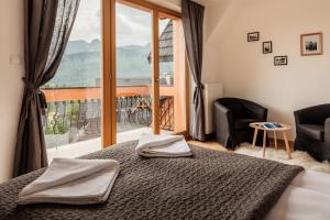 sypialnia z łóżkiem i dużym oknem w obiekcie Domy Mountain Premium w mieście Kościelisko