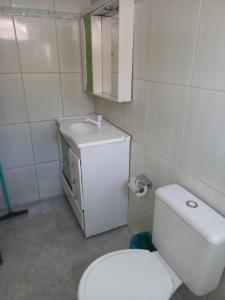 y baño con aseo blanco y lavamanos. en Pousada Estrela Azul, en São Gabriel