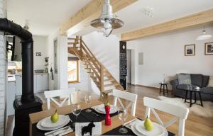 a dining room and living room with a table and chairs at Domy Mountain Premium in Kościelisko