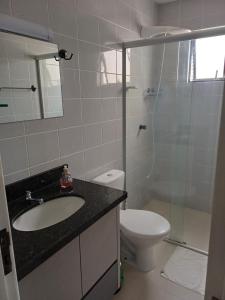 y baño con lavabo, aseo y ducha. en Apartamento aconchegante perto da praia, en Balneário Camboriú