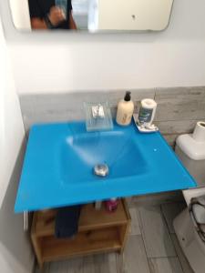 un lavandino blu in bagno con specchio di Apartamento playa picasso a Santa Cruz de Tenerife