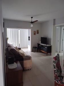 sala de estar con sofá y TV en Apartamento aconchegante perto da praia, en Balneário Camboriú