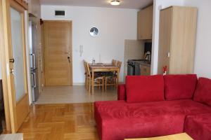 a living room with a red couch and a table at Apartman Božić in Šišava