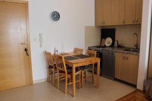 a kitchen with a wooden table with chairs and a sink at Apartman Božić in Šišava