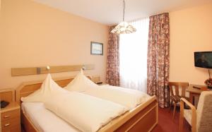 ein Hotelzimmer mit einem Bett und einem Fenster in der Unterkunft Hotel Münchner Löwenbräu in Cuxhaven